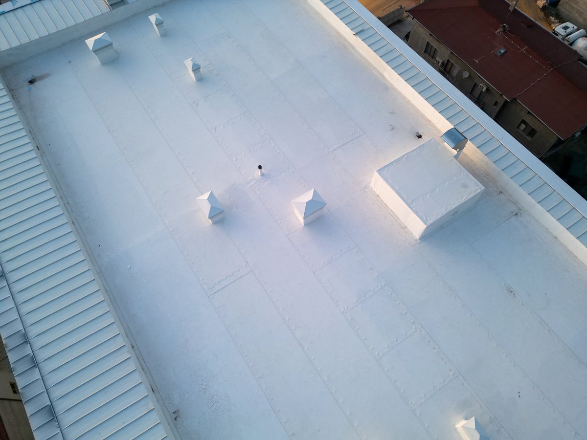 Aerial view of a white industrial rooftop with vents